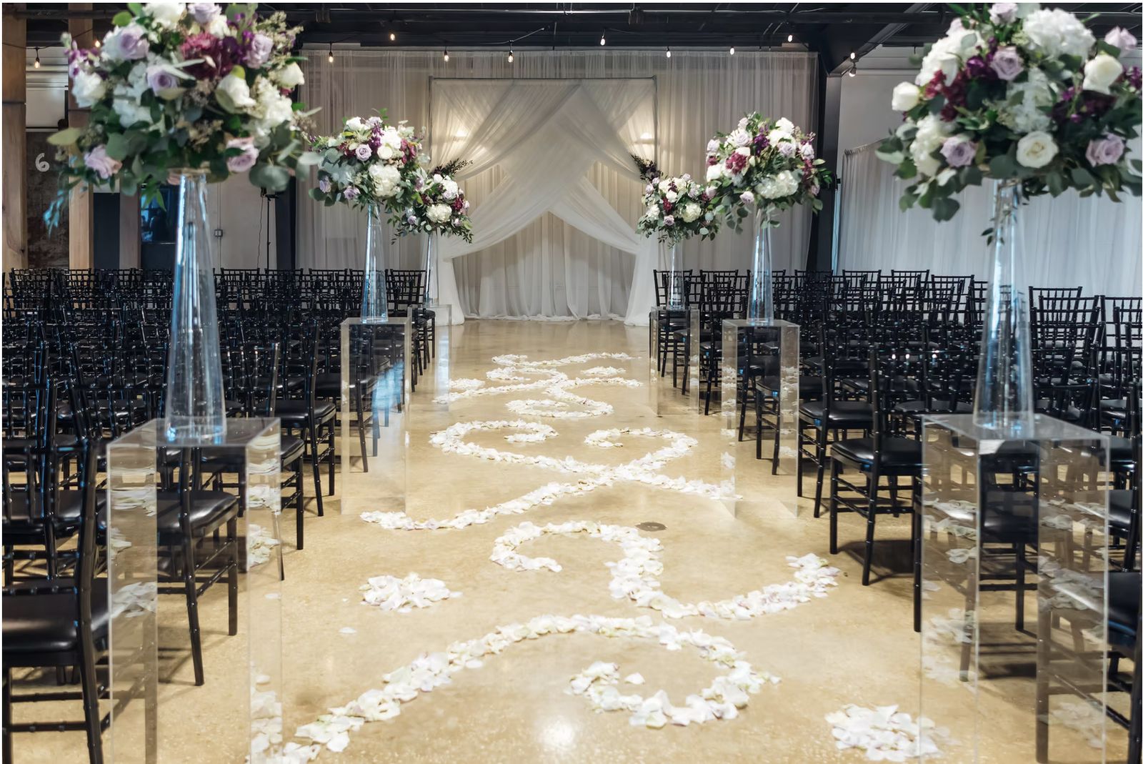 A wedding ceremony aisle laid with petals across polished concrete at Venue 650