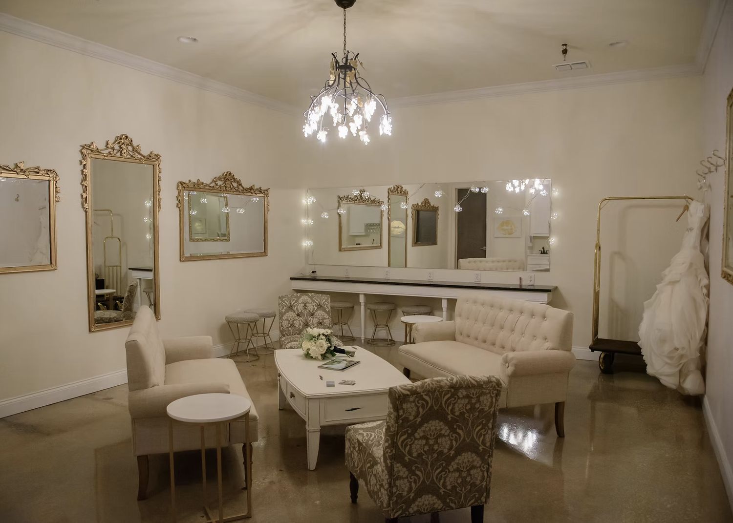 The bridal boutique at Venue 650 with gilt mirrors, a chandelier, seating and a vanity