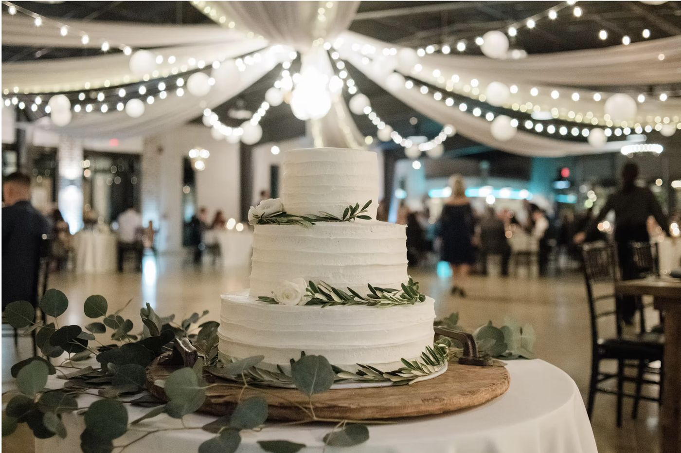 The cake table under string lights