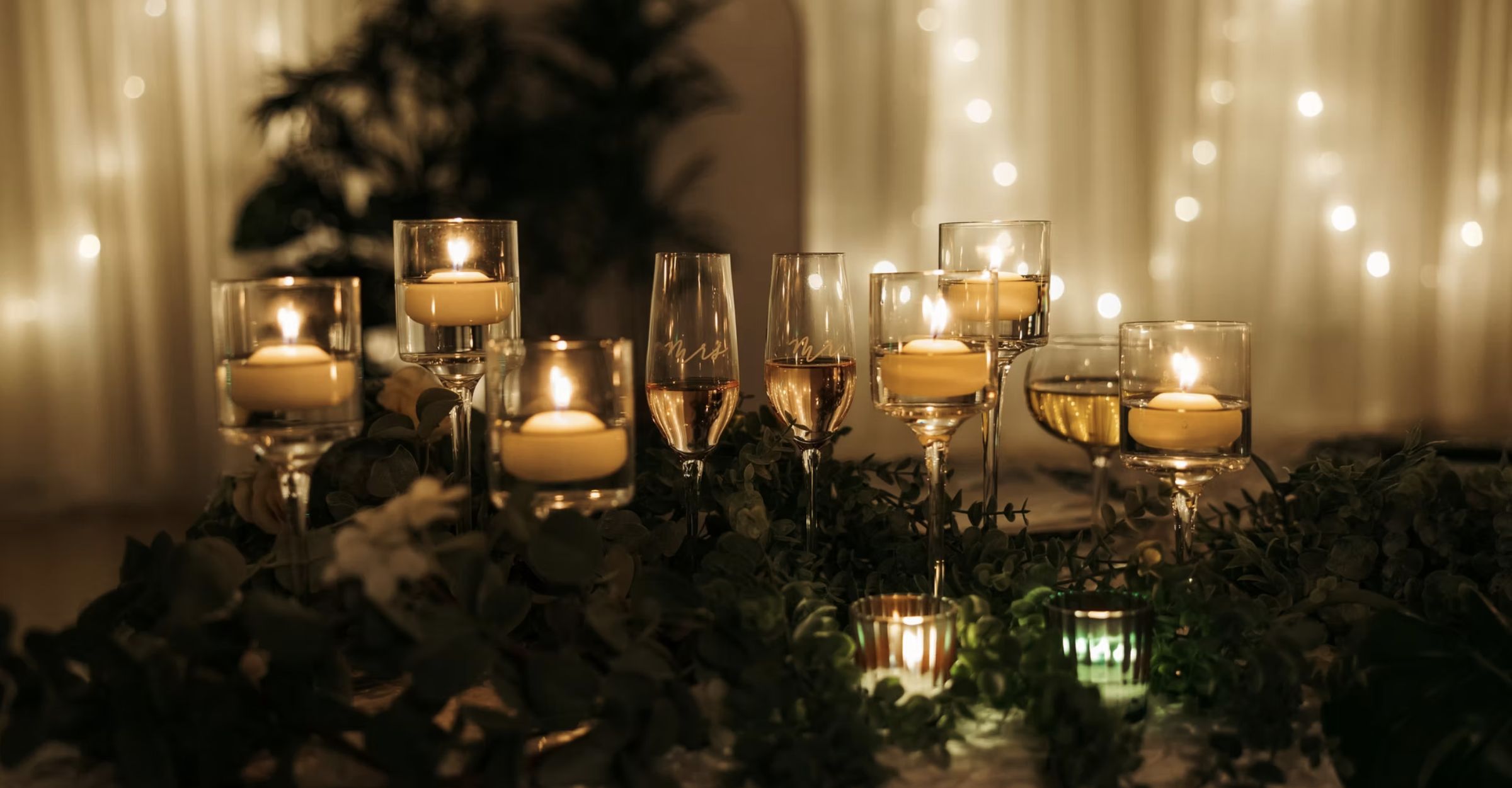 Candles and string lights across the room at dusk